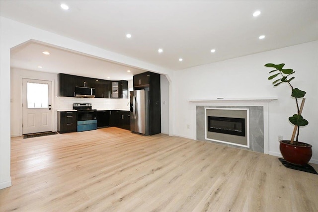 unfurnished living room featuring a premium fireplace and light wood-type flooring