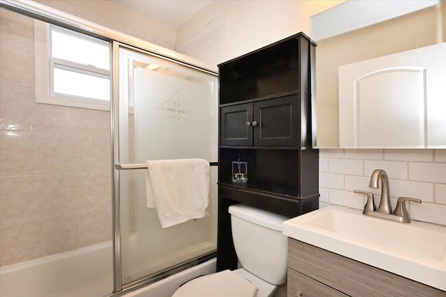 full bathroom featuring vanity, backsplash, enclosed tub / shower combo, and toilet