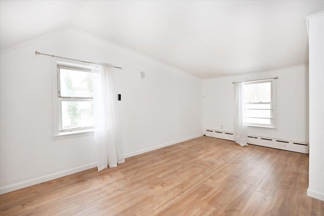 additional living space featuring lofted ceiling, a baseboard heating unit, and light hardwood / wood-style floors