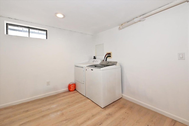 laundry area featuring washing machine and dryer and light wood-type flooring