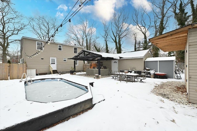 snow covered rear of property with a storage unit