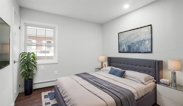 bedroom featuring a baseboard heating unit and dark hardwood / wood-style floors