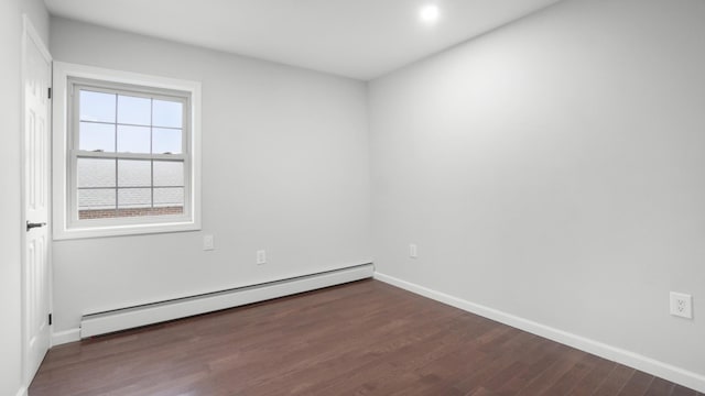 unfurnished room with baseboard heating and dark hardwood / wood-style flooring