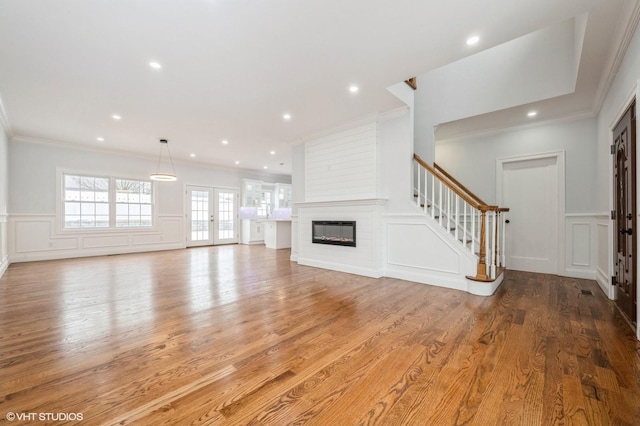 2101 Fir St, Wantagh, NY 11793 - unfurnished living room featuring a decorative wall, crown molding, wood finished floors, stairway, and wainscoting
