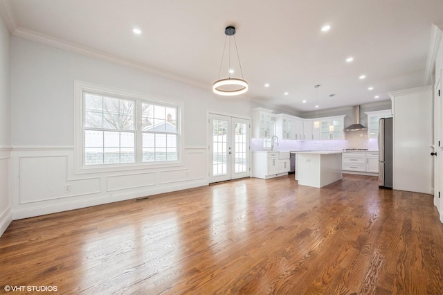 2101 Fir St, Wantagh, NY 11793 - unfurnished living room featuring french doors, ornamental molding, a wainscoted wall, a decorative wall, and dark wood-style floors
