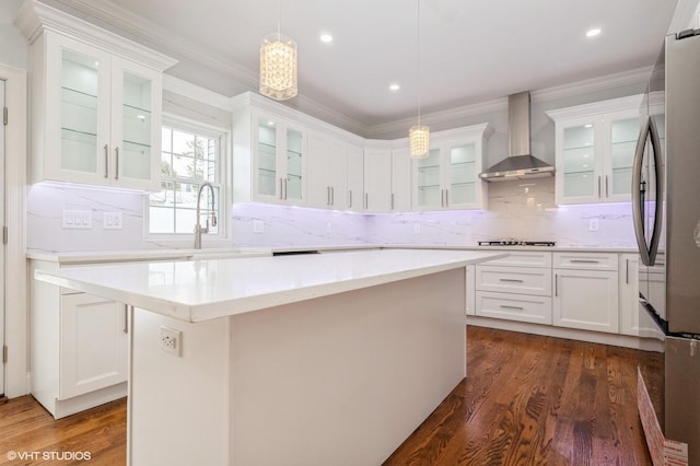 2101 Fir St, Wantagh, NY 11793 - kitchen with wall chimney range hood, crown molding, dark wood-style flooring, white cabinetry, and a center island