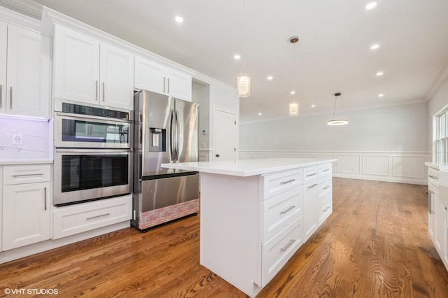 2101 Fir St, Wantagh, NY 11793 - kitchen with stainless steel appliances, ornamental molding, white cabinetry, a kitchen island, and light countertops