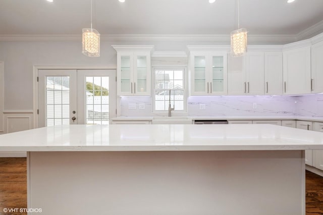 2101 Fir St, Wantagh, NY 11793 - kitchen featuring white cabinetry, dark wood finished floors, ornamental molding, french doors, and glass insert cabinets
