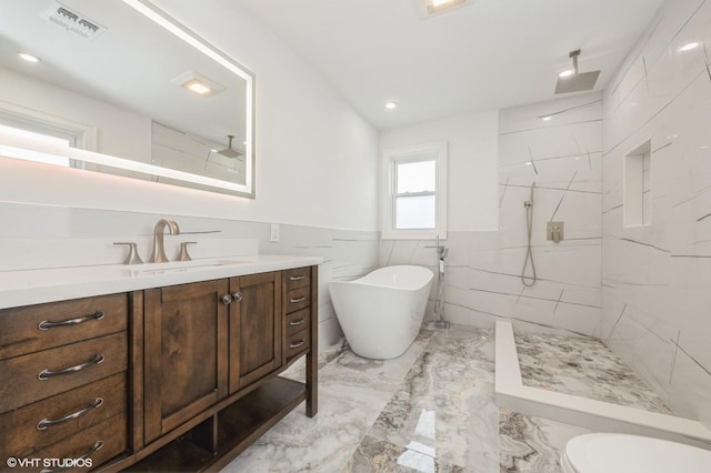 2101 Fir St, Wantagh, NY 11793 - bathroom with marble tiled floors, vanity, a freestanding tub, a marble finish shower, and tile walls