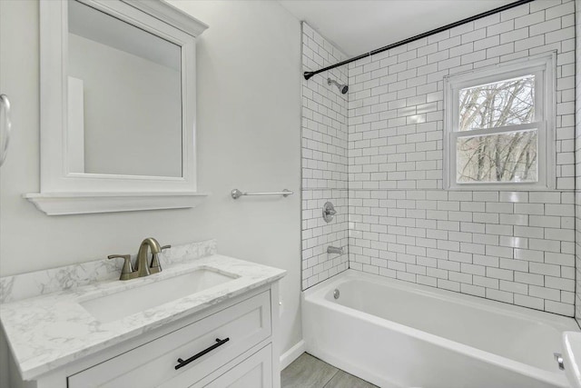 bathroom featuring tiled shower / bath combo and vanity