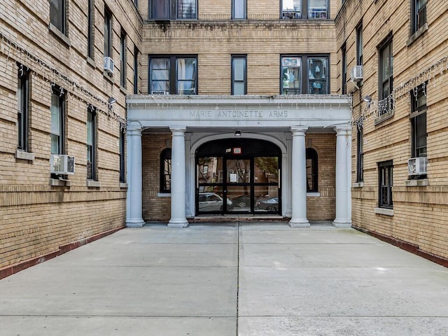 91 E 208th St Unit 3K, Bronx, NY 10467 - doorway to property with brick siding and cooling unit