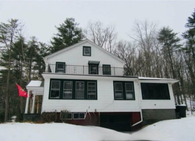 view of snowy exterior with a balcony