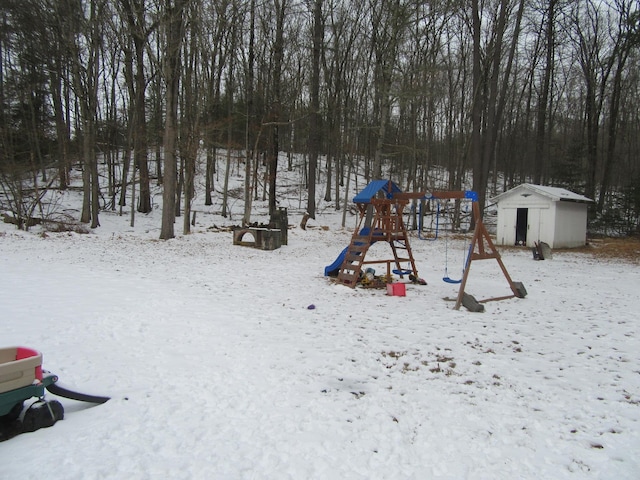 snow covered playground featuring a shed