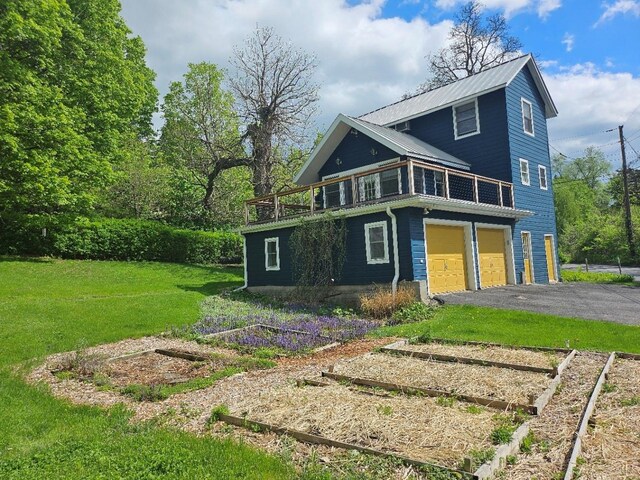 807 Lucas Avenue Ext, Hurley, NY 12443 - view of front of house featuring a garden, a front yard, a garage, driveway, and a balcony