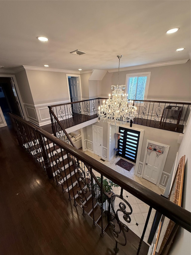 stairs with recessed lighting, visible vents, crown molding, and wood finished floors