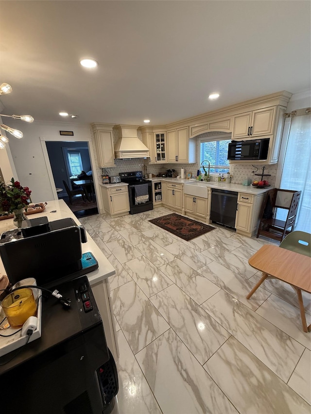 kitchen featuring glass insert cabinets, cream cabinets, and black appliances