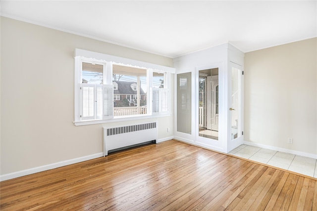 spare room featuring light hardwood / wood-style flooring and radiator heating unit