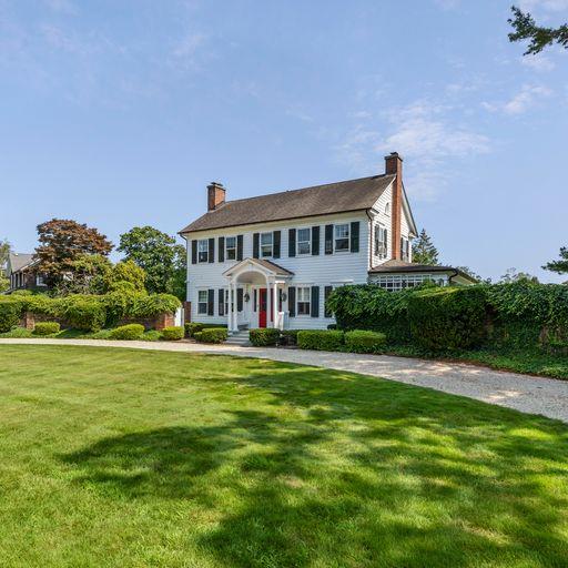 colonial-style house featuring a front lawn