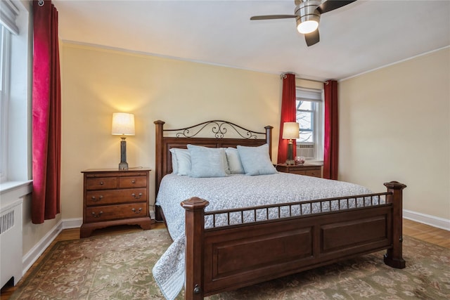 bedroom with crown molding, ceiling fan, radiator heating unit, and dark hardwood / wood-style floors