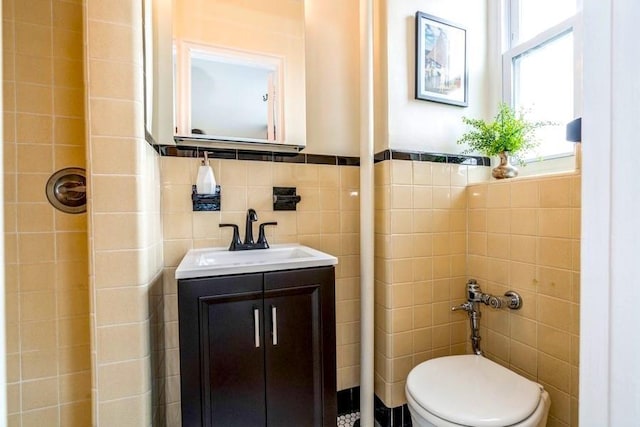 bathroom with tile walls, vanity, and toilet