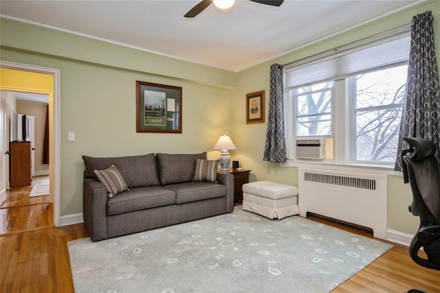 living room featuring cooling unit, radiator, hardwood / wood-style floors, and ceiling fan