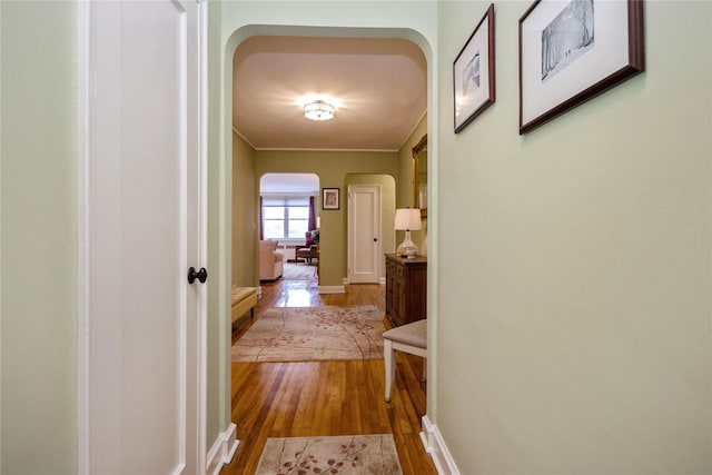 hall with light hardwood / wood-style flooring and ornamental molding