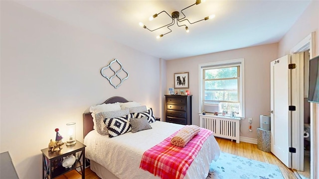 bedroom with radiator and light hardwood / wood-style floors