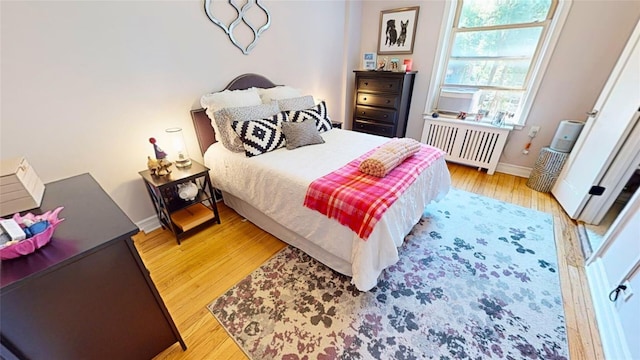 bedroom with radiator and light hardwood / wood-style floors