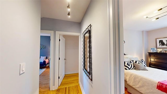 hall with rail lighting and light wood-type flooring