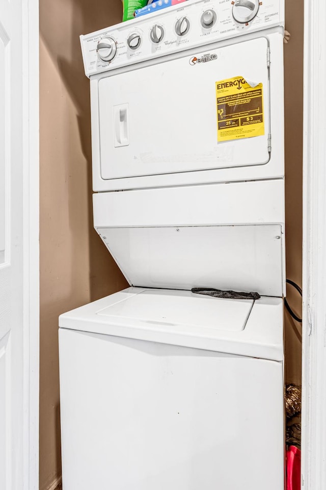 clothes washing area featuring stacked washing maching and dryer