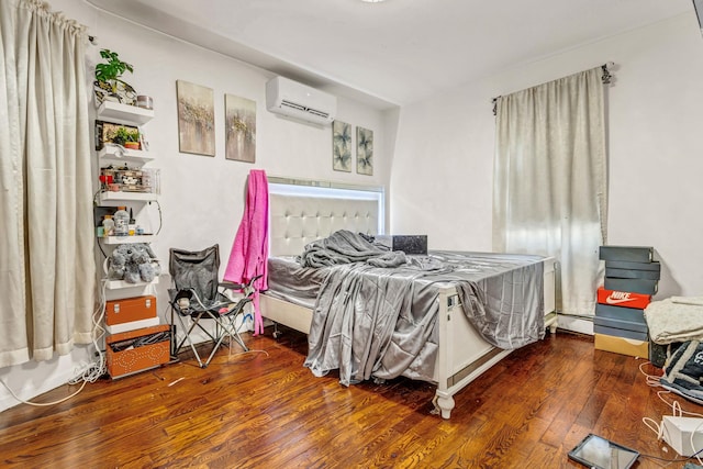 bedroom featuring a wall mounted air conditioner and dark wood-type flooring