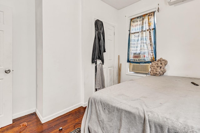 bedroom with cooling unit and dark hardwood / wood-style flooring