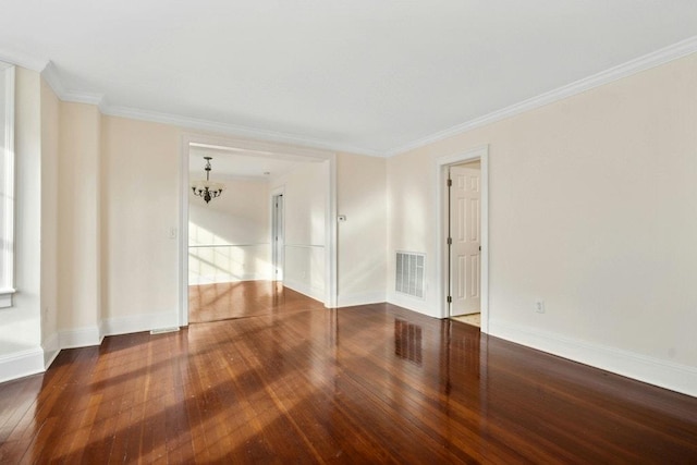 unfurnished room featuring hardwood / wood-style flooring, ornamental molding, and a chandelier