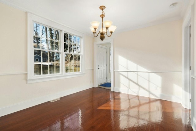 unfurnished room featuring crown molding, wood-type flooring, and a chandelier