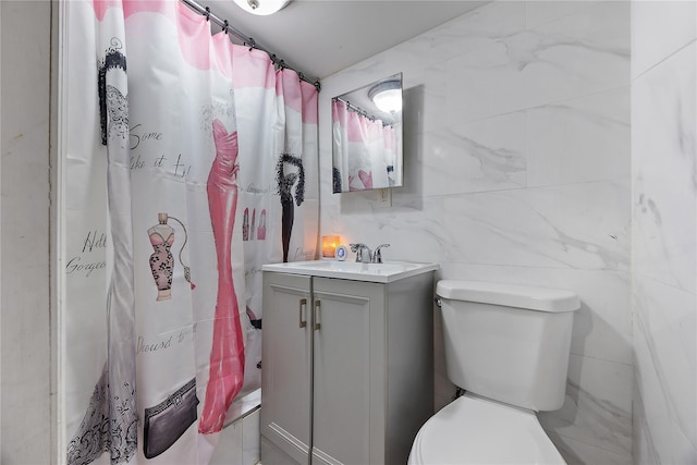 bathroom with walk in shower, vanity, toilet, and tile walls