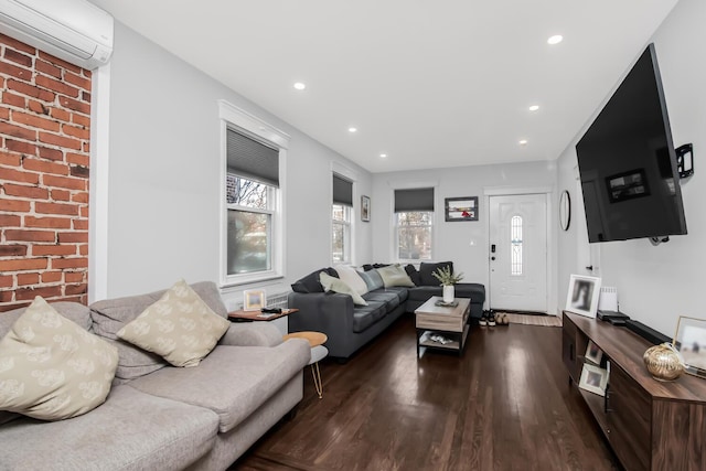 living room with a wall mounted AC and dark hardwood / wood-style flooring