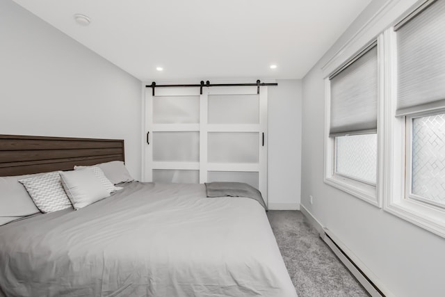 bedroom featuring a baseboard radiator, a barn door, and light carpet