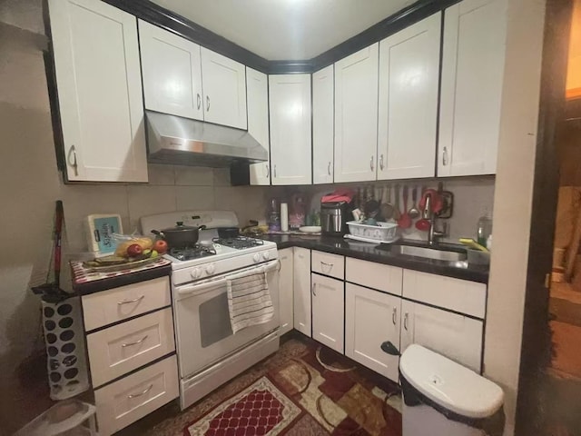 kitchen featuring tasteful backsplash, sink, white cabinets, and gas range gas stove