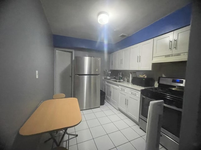 kitchen featuring sink, light tile patterned floors, stainless steel appliances, and white cabinets