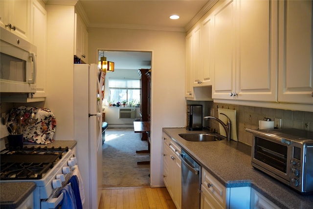 334 Central Park Ave Unit H8, Scarsdale, NY 10583 - kitchen with a sink, appliances with stainless steel finishes, a baseboard heating unit, dark countertops, and white cabinetry
