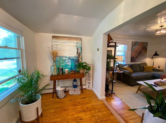 foyer featuring a baseboard radiator, vaulted ceiling, and light hardwood / wood-style flooring