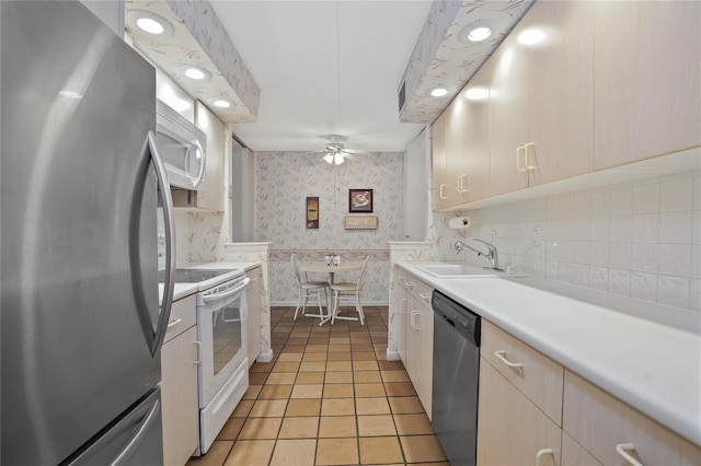 kitchen featuring stainless steel appliances, sink, light tile patterned floors, and ceiling fan