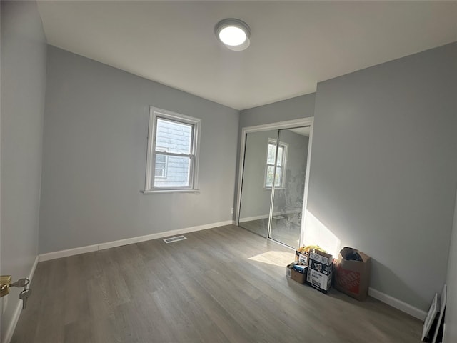 unfurnished bedroom featuring wood-type flooring and a closet