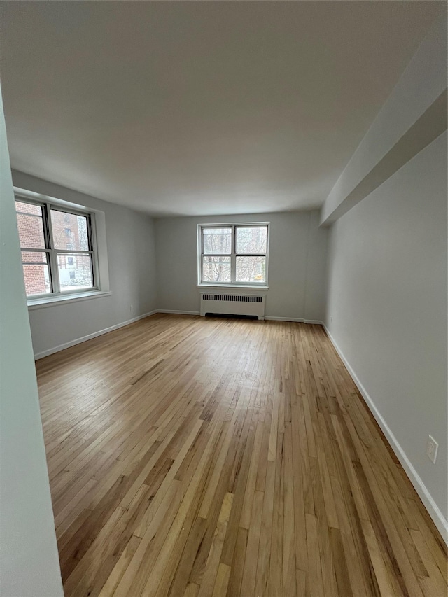 spare room with radiator and light wood-type flooring