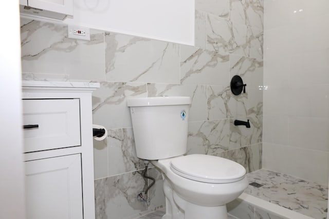 bathroom featuring tiled shower, tile walls, and toilet