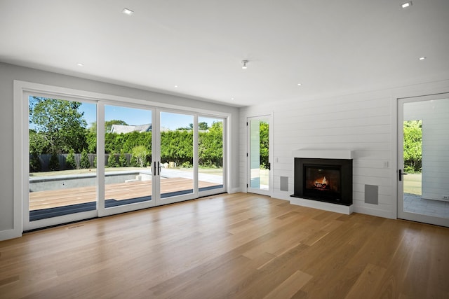 245 Mill Rd, Westhampton Beach, NY 11978 - unfurnished living room with wood finished floors, a glass covered fireplace, and recessed lighting