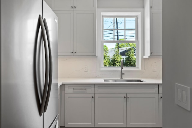 245 Mill Rd, Westhampton Beach, NY 11978 - kitchen featuring freestanding refrigerator, a sink, decorative backsplash, light countertops, and white cabinets