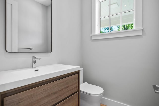 245 Mill Rd, Westhampton Beach, NY 11978 - half bathroom with toilet, vanity, and baseboards