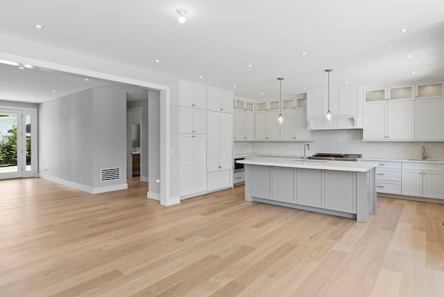 245 Mill Rd, Westhampton Beach, NY 11978 - kitchen with a sink, light countertops, light wood-style flooring, tasteful backsplash, and recessed lighting