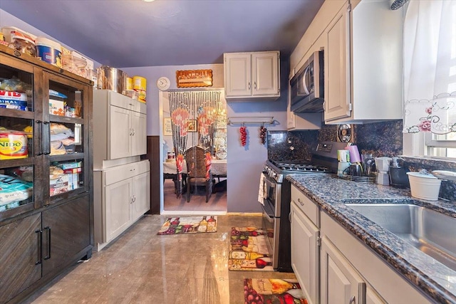 kitchen with stainless steel appliances, sink, and white cabinets